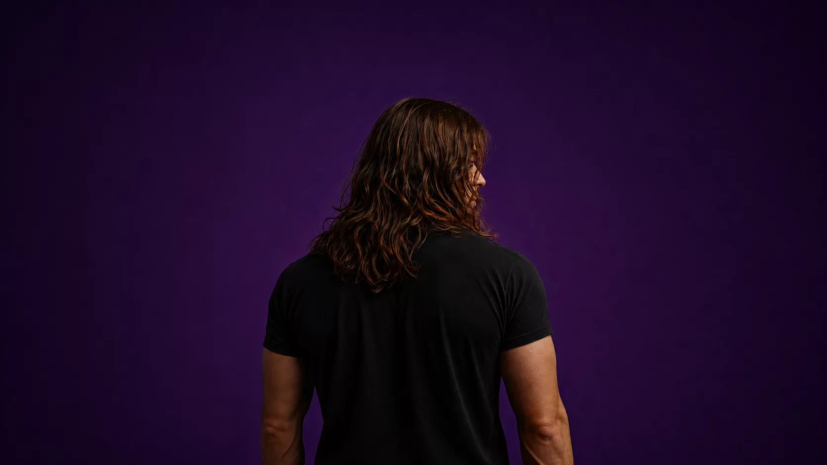 Benoit Meunier, photographed from behind against a purple studio backdrop